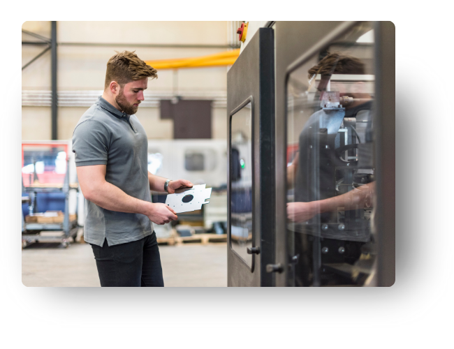 Manufacturing engineer examines a part as it comes off a CNC mill